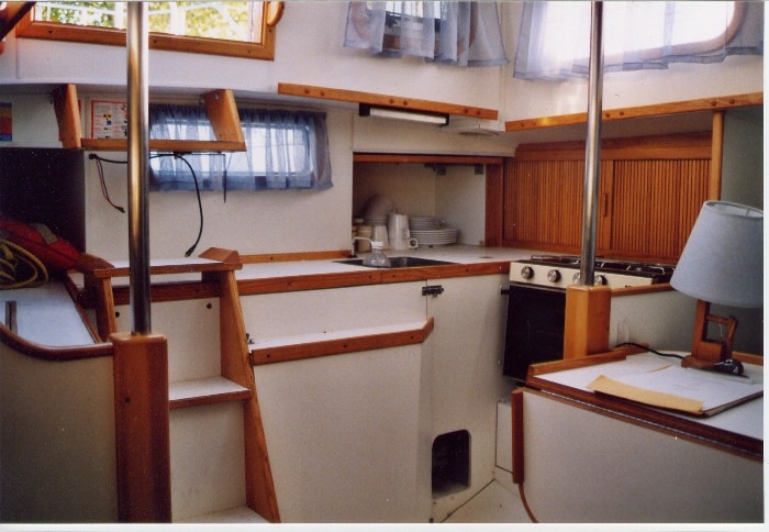 La cuisine d'Elfe : cuisinière, évier, rangements en bois.