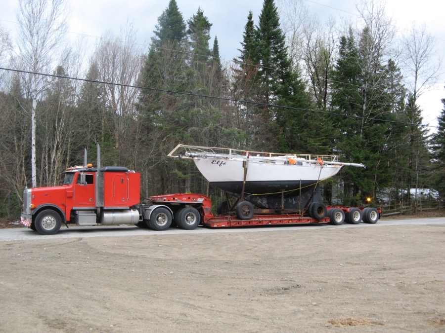 Elfe chargé sur une remorque surbaissée tirée par un camion semi-remorque rouge.
