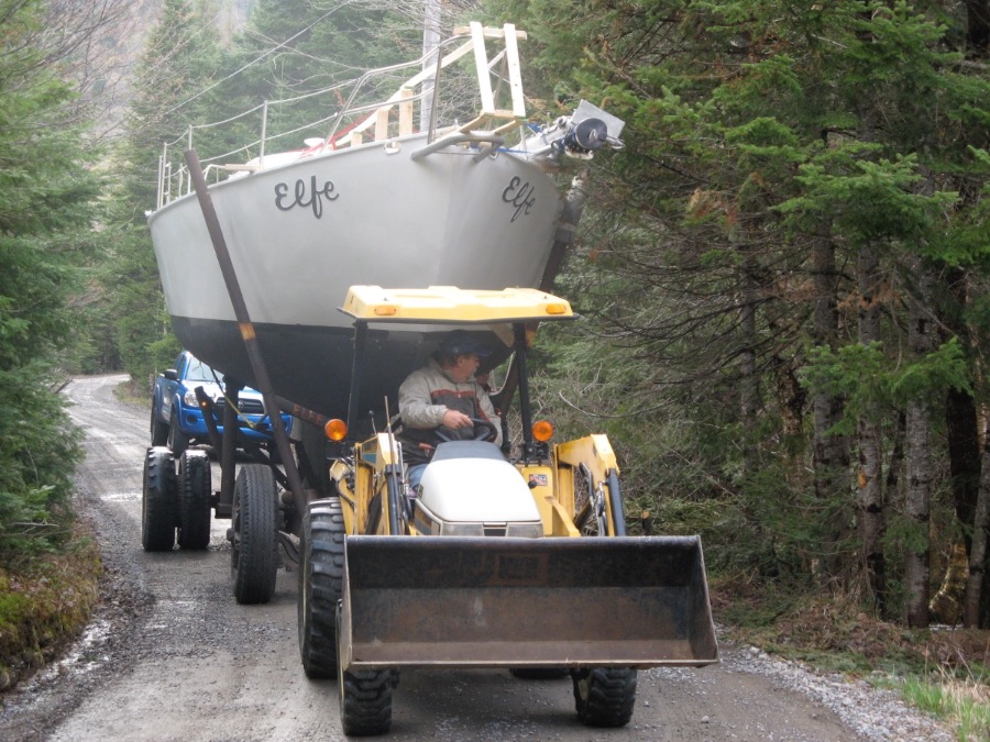 Elfe tracté par un tracteur de ferme sur un chemin forestier, le nom « Elfe » peint des deux côtés de l'étrave.