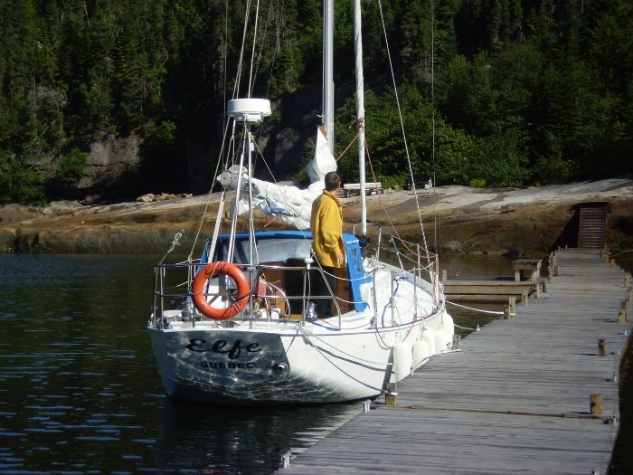 Équipier en ciré jaune sur le pont d'Elfe, amarré au fond du fjord.